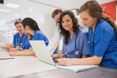 Medical student smiling at the camera during class clipart