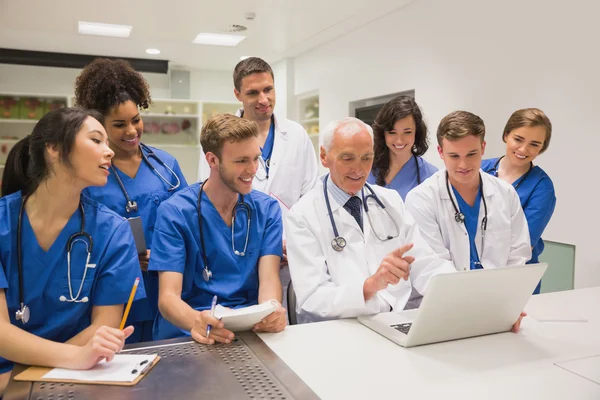 Medical students and professor using laptop — Stock Photo, Image