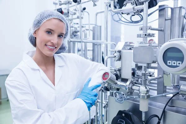 Smiling scientist leaning against gauge — Stock Photo, Image