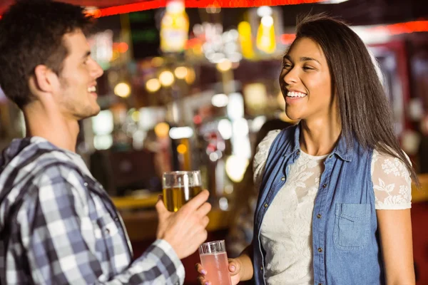 Smiling friends drinking beer and mixed drink — Stock Photo, Image