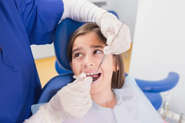 Odontólogo pediátrico examinando a un paciente joven asustado — Foto de Stock