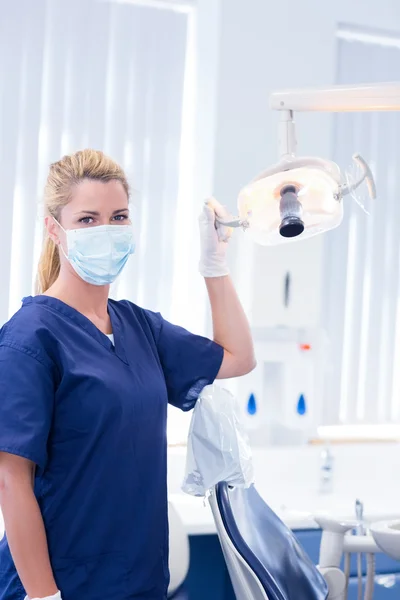 Стоматолог в маске держит свет — стоковое фото