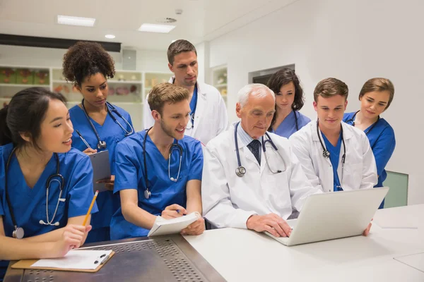 Medical students and professor using laptop — Stock Photo, Image