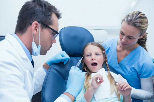 Dentista con asistente examinando los dientes de las niñas —  Fotos de Stock