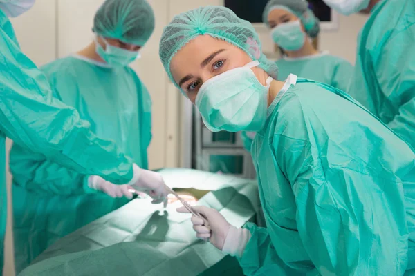 Estudiante de medicina mirando la cámara durante la cirugía de práctica —  Fotos de Stock