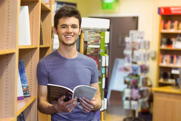 Studente universitario sorridente che tiene un libro di testo — Foto Stock