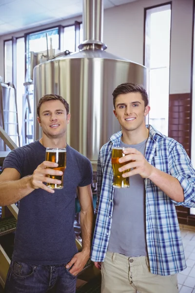 Jonge mannen houden van een pint bier glimlachen op camera — Stockfoto
