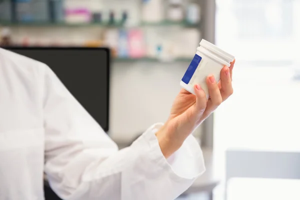 Farmacêutico júnior segurando frasco medicina — Fotografia de Stock