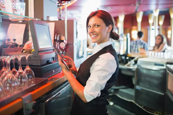 Ładny barmanka za pomocą ekranu dotykowego do — Zdjęcie stockowe