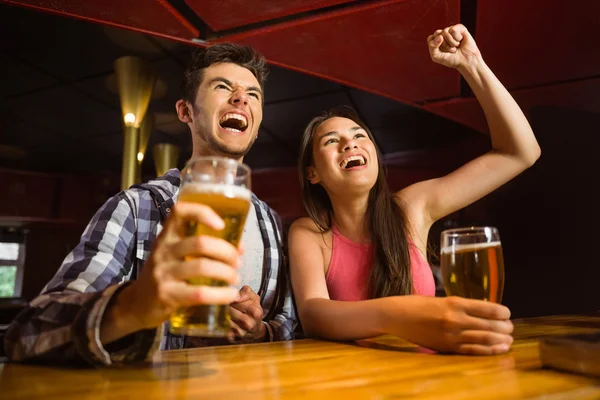 Happy friends drinking beer and cheering together — Stock Photo, Image