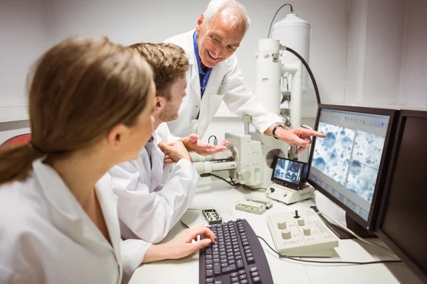 Science students looking at microscopic — Stock Photo, Image