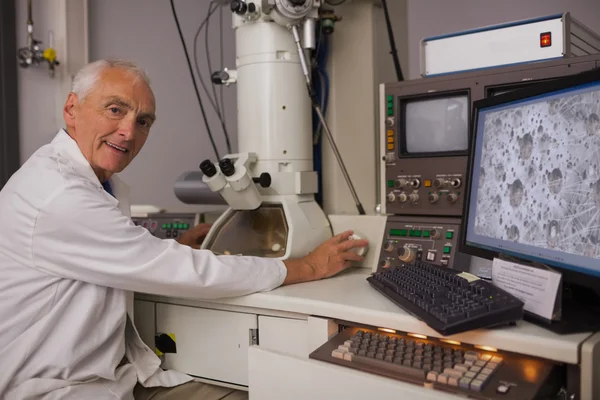 Biochemiker mit großem Mikroskop und Computer — Stockfoto