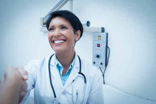 Dentiste joyeux serrant la main du patient — Photo