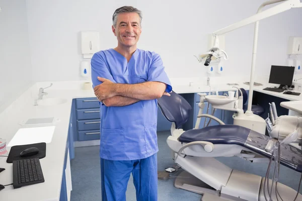 Happy dentist standing with arms crossed — Stock Photo, Image