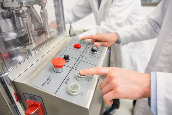 Pharmacist pressing button on machine — Stock Photo, Image