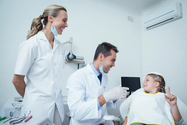 Mannelijke tandarts en assistent praten met meisje — Stockfoto