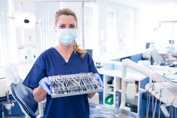 Dentista em esfrega azul segurando bandeja de ferramentas — Fotografia de Stock