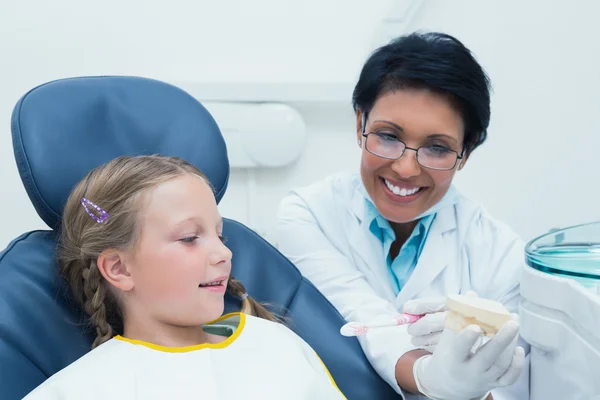 Vrouwelijke tandarts onderwijs meisje Hoe borstel tanden — Stockfoto