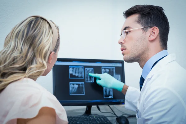 Dentista mostrando mulher sua boca raio-x no computador — Fotografia de Stock