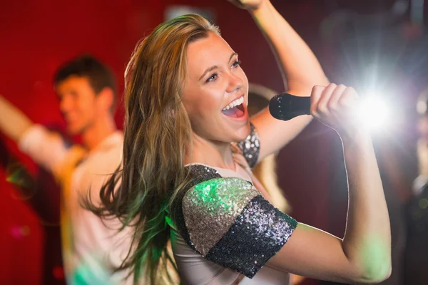 Feliz loira cantando karaoke em microfone — Fotografia de Stock