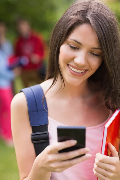 Hübsche Studentin schickt einen Text nach draußen auf den Campus — Stockfoto
