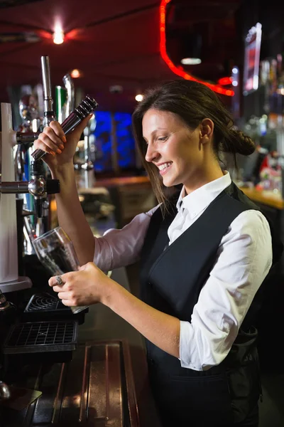 Barmaid feliz puxando uma caneca de cerveja — Fotografia de Stock