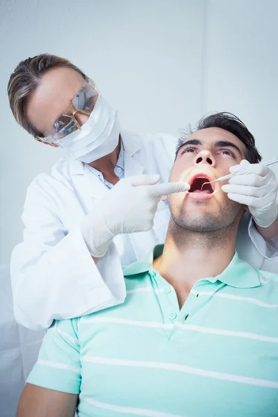 Female dentist examining mans teeth — Stock Photo, Image