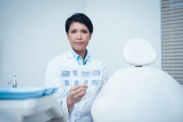 Retrato del dentista femenino sosteniendo rayos X — Foto de Stock