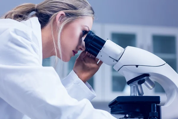 Science student looking through microscope in the lab — Stock Photo, Image