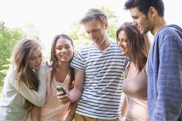 Glückliche Studenten, die draußen auf dem Campus auf ihr Smartphone schauen — Stockfoto