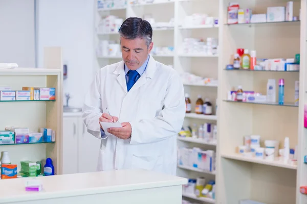 Focused pharmacist writing down notes — Stock Photo, Image