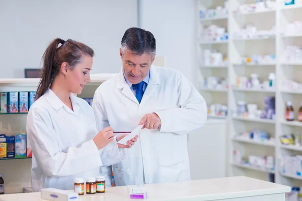 Apotheker en zijn stagiair samen te werken — Stockfoto