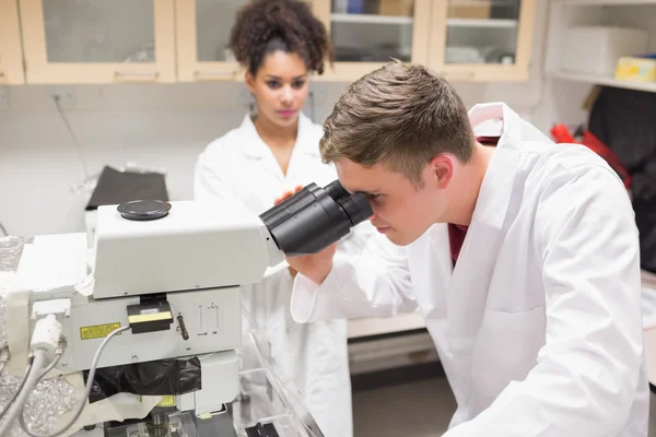 Junge Wissenschaftlerin arbeitet mit Mikroskop — Stockfoto