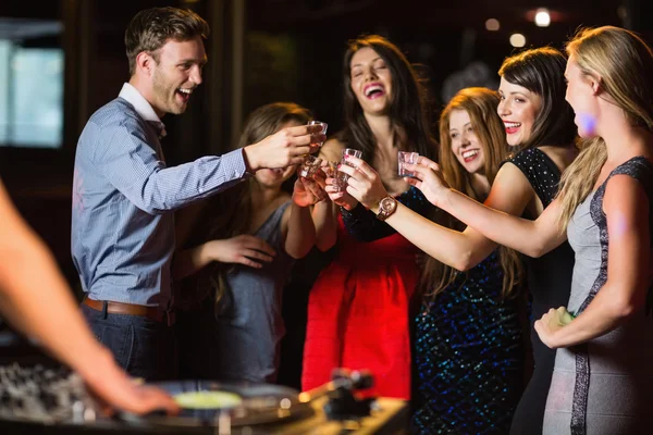 Amigos felizes bebendo tiros pela cabine dj — Fotografia de Stock