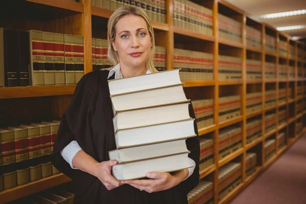 Advogado segurando pilha pesada de livros de pé — Fotografia de Stock