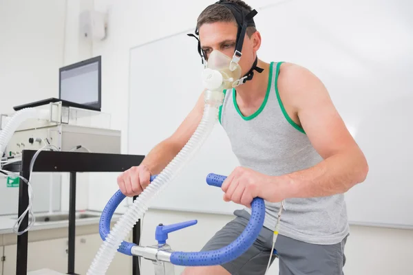 Hombre haciendo la prueba de aptitud en bicicleta estática — Foto de Stock