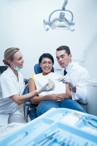 Dentists showing woman prosthesis teeth — Stock Photo, Image