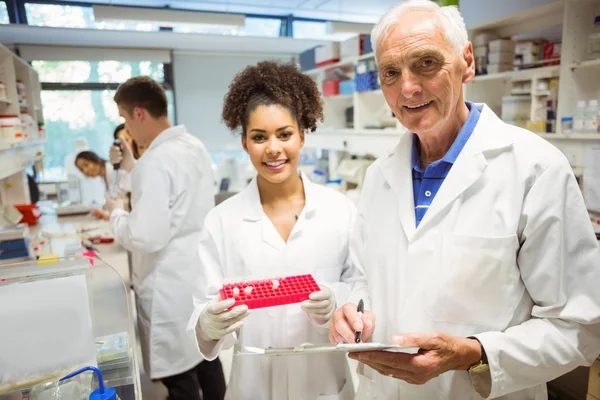 Profesor y estudiante sonriendo a la cámara en el laboratorio — Foto de Stock