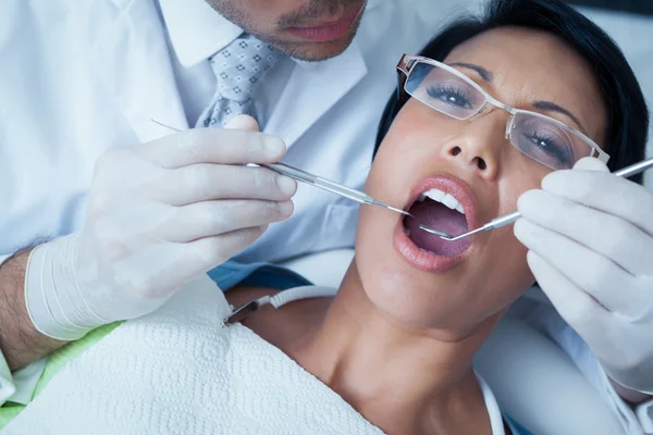 Dentista masculino examinando los dientes de las mujeres — Foto de Stock