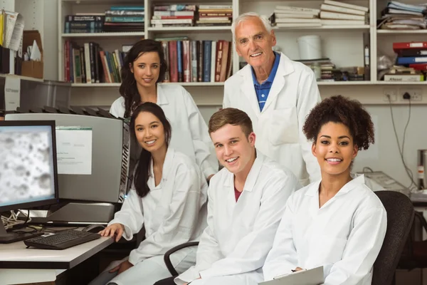 Wissenschaftsstudenten lächeln mit Professor in die Kamera — Stockfoto