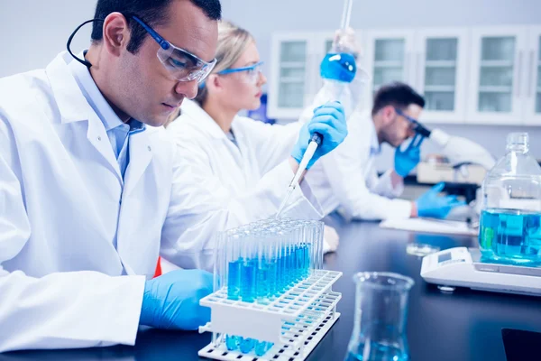 Naturwissenschaftsstudent benutzt Pipette im Labor, um Reagenzgläser zu füllen — Stockfoto