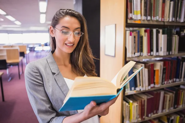 Pretty student reading book in library — Stock Photo, Image