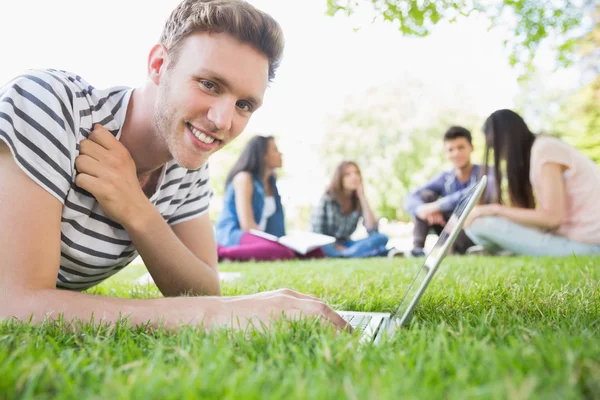 Lycklig student med sin laptop utanför — Stockfoto