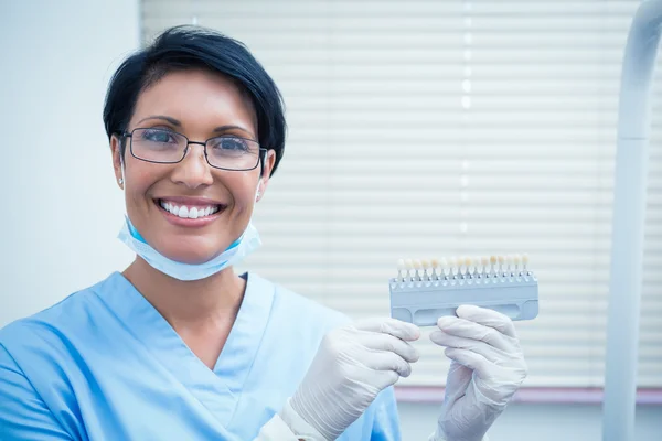 Smiling female dentist holding teeth model — Stock Photo, Image
