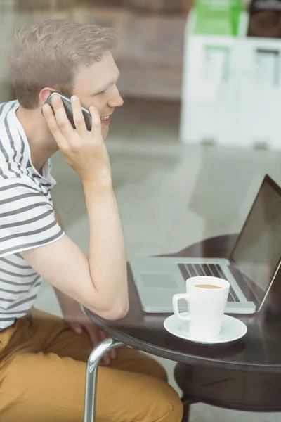 Student met behulp van laptop en smartphone — Stockfoto