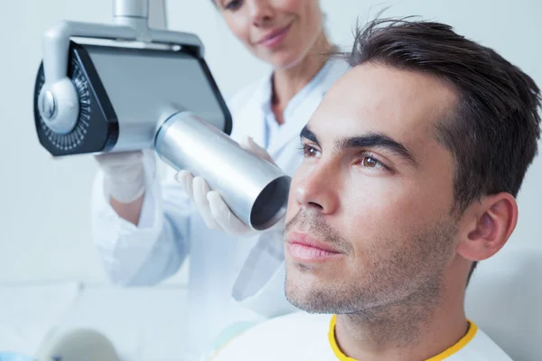 Serious young man undergoing dental checkup — Stock Photo, Image