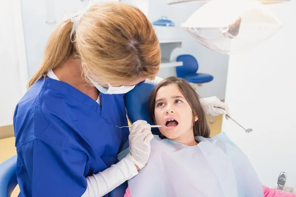 Детский дантист осматривает своего молодого пациента — стоковое фото