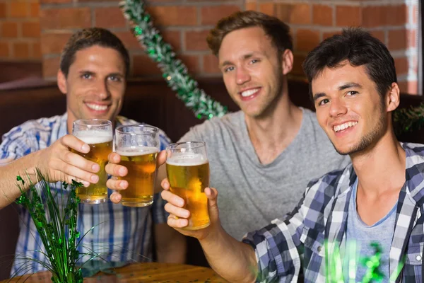 Feliz amigos brindar com pints de cerveja no dia patricks — Fotografia de Stock