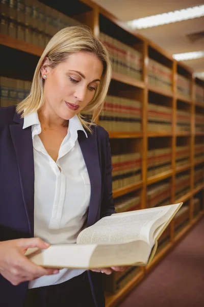 Serious librarian reading a book — Stock Photo, Image