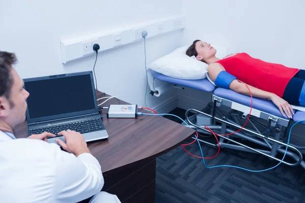 Doctor checking blood pressure of woman — Stock Photo, Image